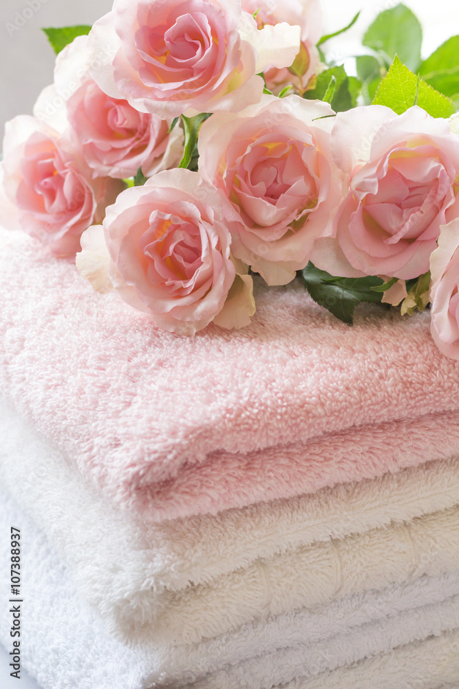 Folded towels on bathroom counter with ligh pink roses Folded towels on bathroom counter with ligh pink roses
