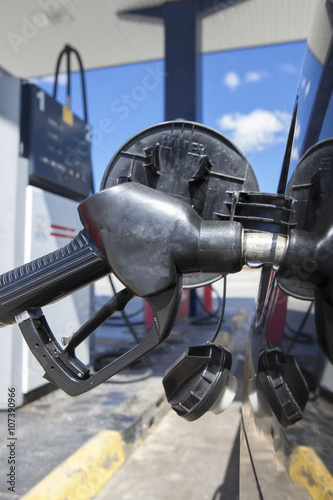 Car refueling on a petrol station. Nozzle detail