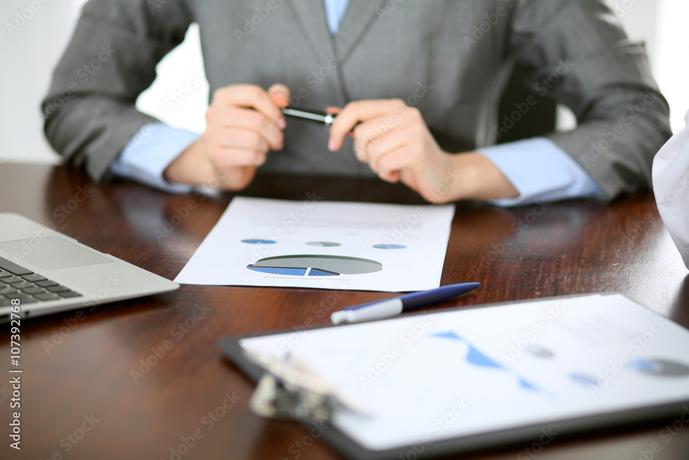 Close up of unknown business people at meeting discussing financial results Close up of unknown business people at meeting discussing financial results