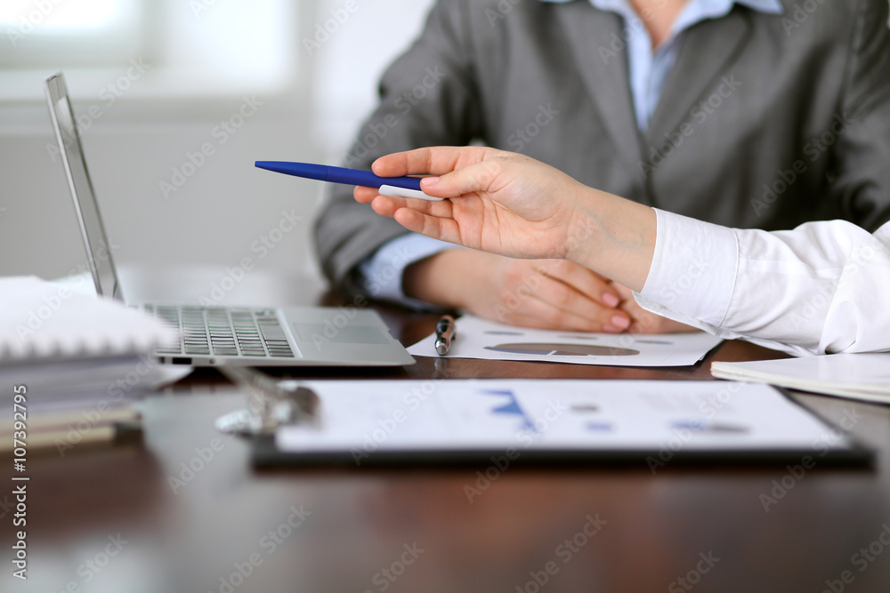 Close up of unknown business people at meeting discussing financial results Close up of unknown business people at meeting discussing financial results