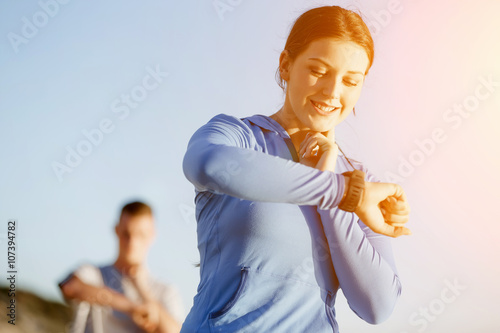 Runner woman with heart rate monitor running on beach