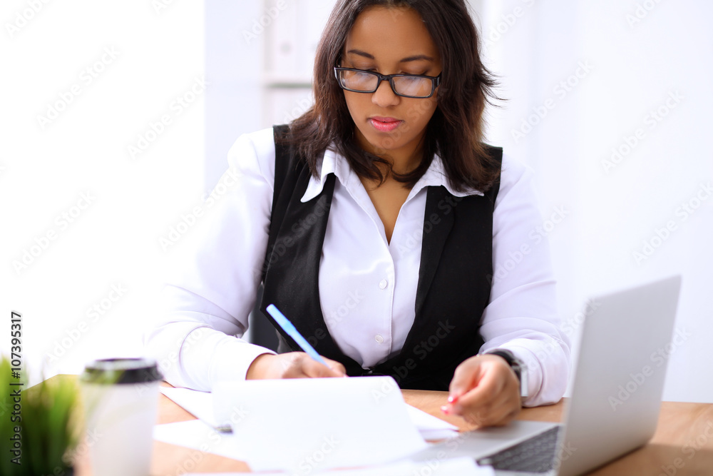 African american business woman is busy with paper job in office while sun shines outdoors African american business woman is busy with paper job in office while sun shines outdoors