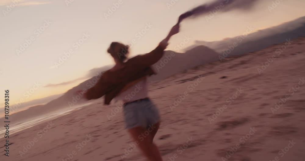 Attractive Boho Hipster Girl running on Beach with smoke flare Attractive Boho Hipster Girl running on Beach with smoke flare