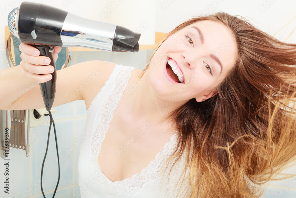Fototapeta premium long haired woman drying hair in bathroom