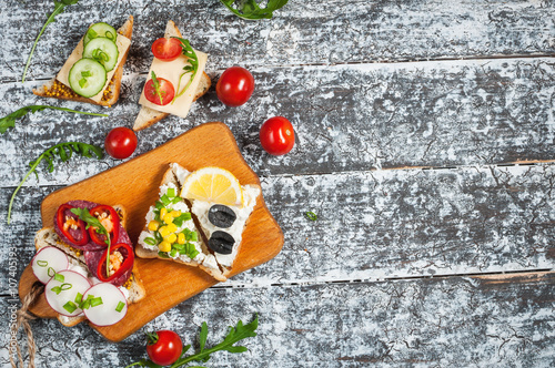 Variety of open sandwiches with different toppings on white backdrop