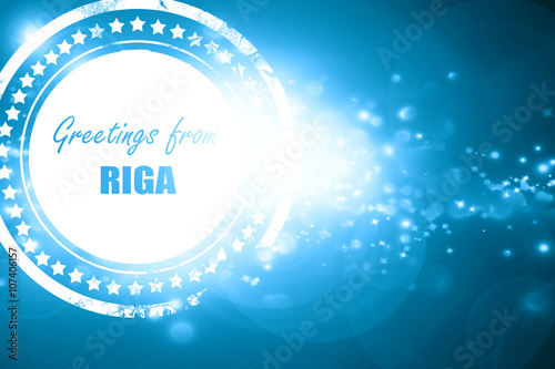 Blue stamp on a glittering background: Greetings from riga