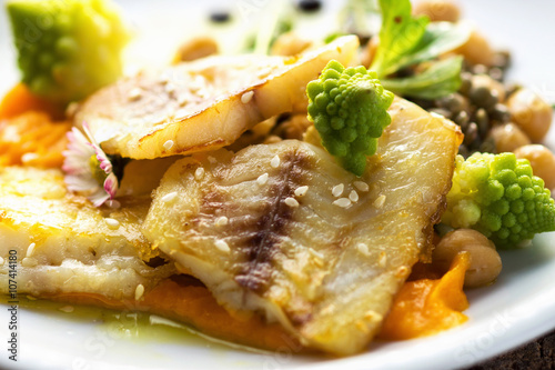 Fish fillet with chickpeas, carrot puree and vegetables photo