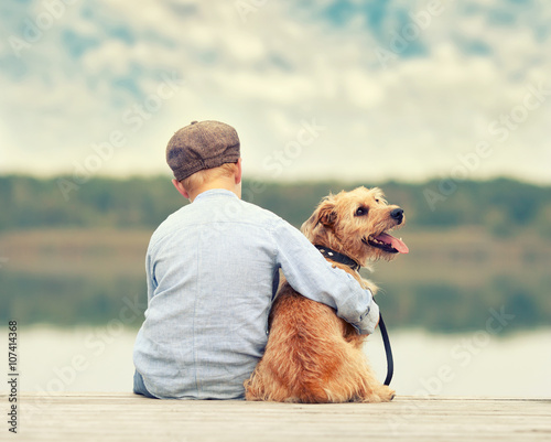 mein bester Freund, Junge sitzt mit seinem Hund am Steg photo