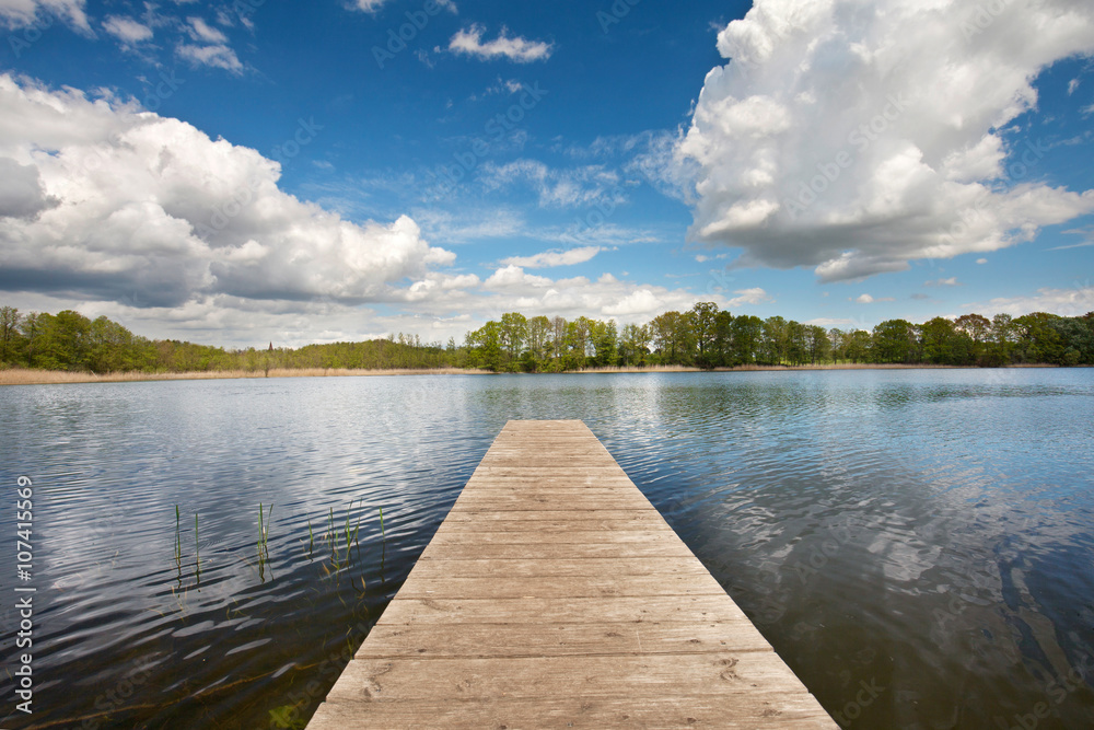 Obraz premium Zabawa kąpielowa nad jeziorem z pomostem latem