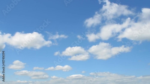 Time lapse fast moving white clouds and blue sky.