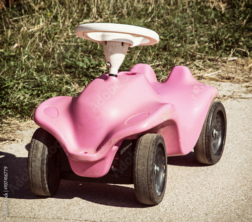 Pink toy car in outdoor photo