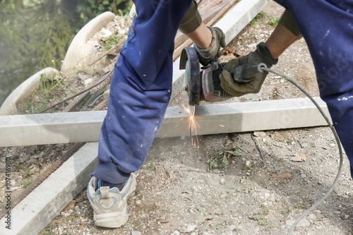 Construction worker cutting a reinforced concrete pillar