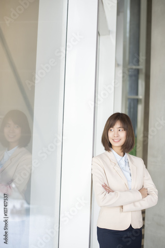 Attractive asian business woman smiling outside office Free Download Attractive asian business woman smiling outside office - GFXLoad