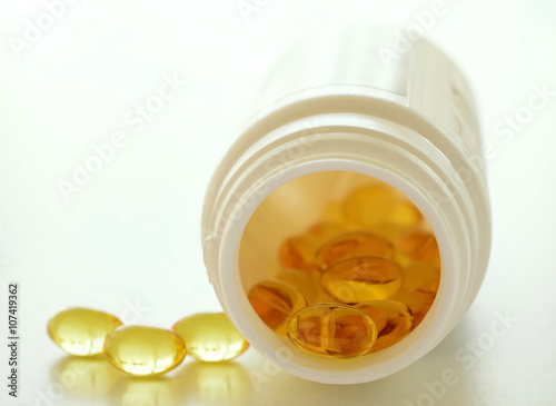 Omega 3 capsules spilling from a bottle