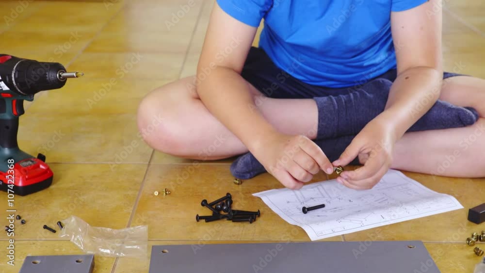 Boy trying screws if fit together Boy trying screws if fit together