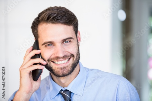 Portrait of happy businessman talking on mobile phone
