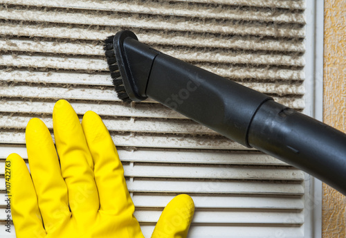 Hand in yellow glove and vacuum cleaner pipe photo