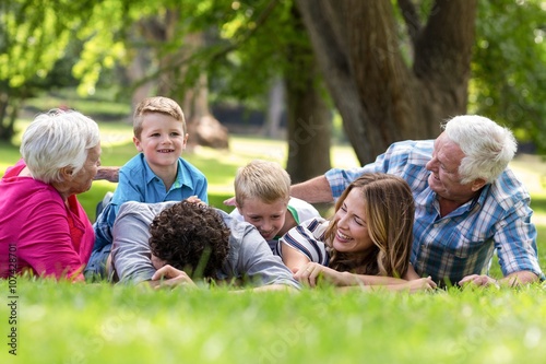 Smiling family lying in the grass in the garden