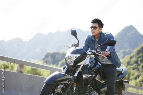 Young man riding motorcycle photo