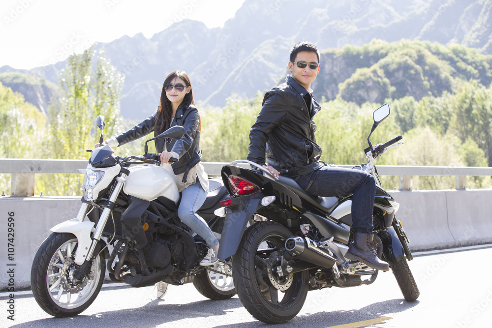 Obraz premium Young couple riding motorcycle together