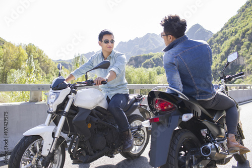 Young men riding motorcycle