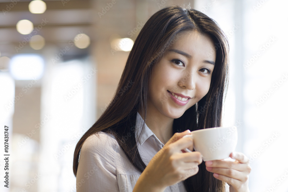 Young woman drinking coffee in caf_ Young woman drinking coffee in caf_