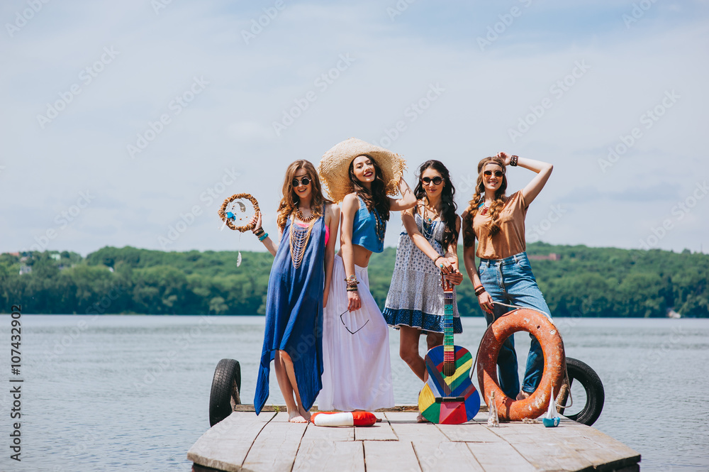 Obraz premium four beautiful girl friends on the dock