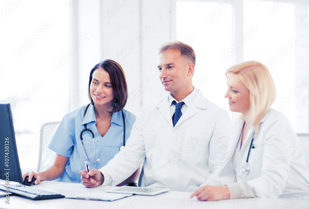 doctors looking at computer on meeting