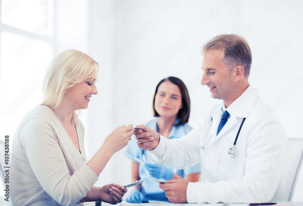 doctor giving tablets to patient in hospital