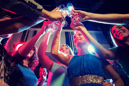 smiling friends with glasses of champagne in club photo