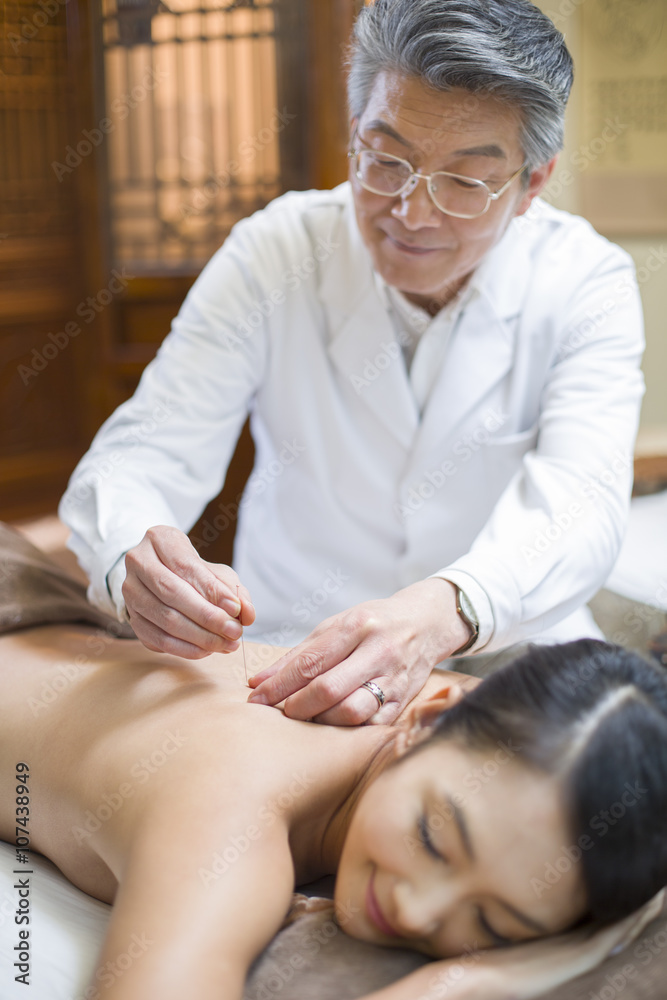Young woman receiving acupuncture Young woman receiving acupuncture