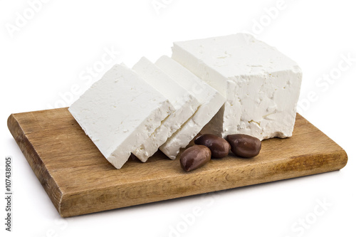 Sliced fresh white cheese from cow's milk with kalamata black olives on wooden board and white background