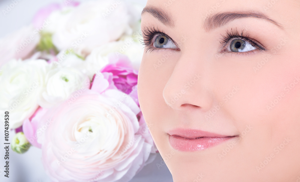 close up portrait of beautiful woman over flowers background