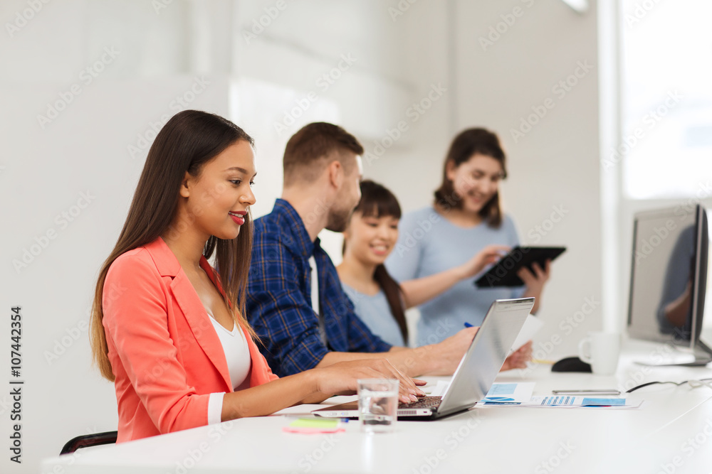 happy african woman over creative team at office happy african woman over creative team at office