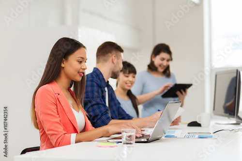 happy african woman over creative team at office