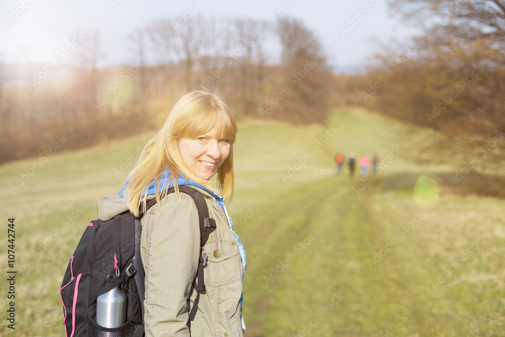 Frau wandert bei Sonnenschein in Gruppe Frau wandert bei Sonnenschein in Gruppe