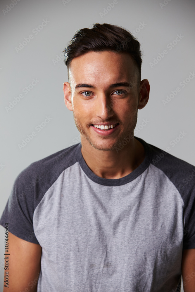 Fototapeta premium Vertical waist up studio portrait of smiling young man