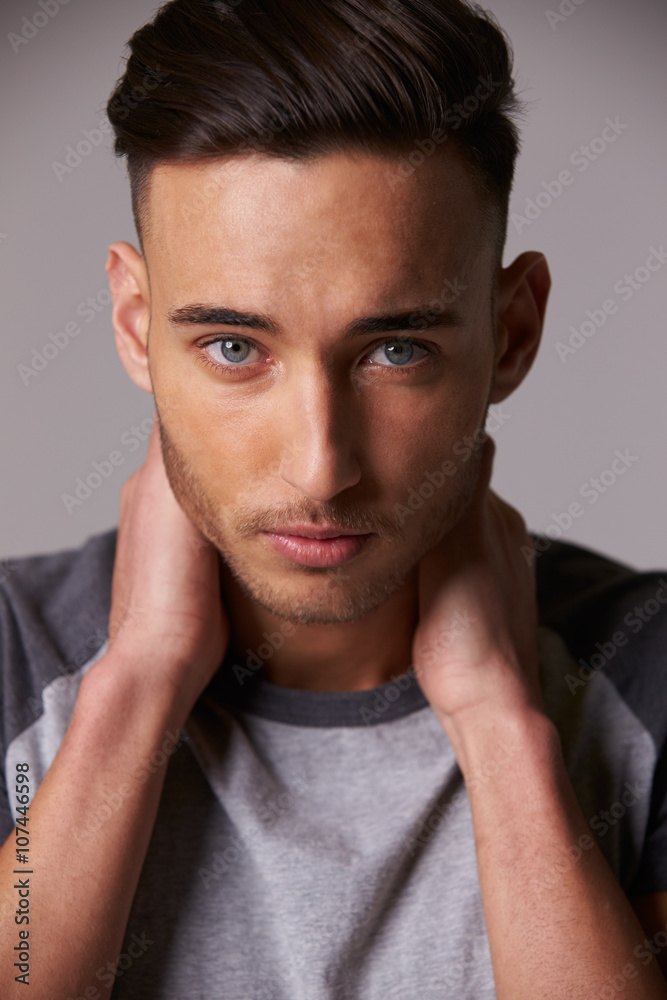 Obraz premium Vertical portrait of young man, holding his neck