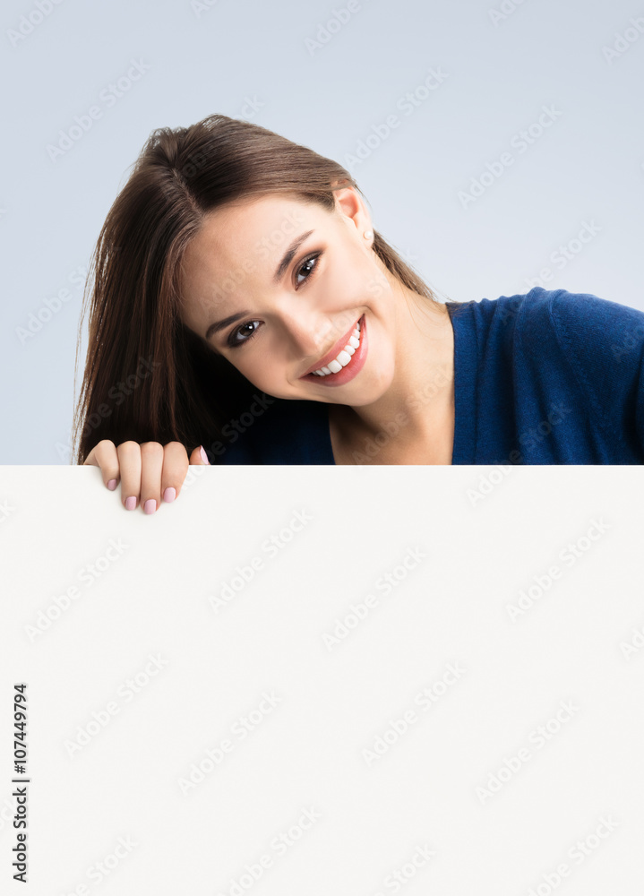 Brunette woman in casual clothing showing blank signboard Brunette woman in casual clothing showing blank signboard