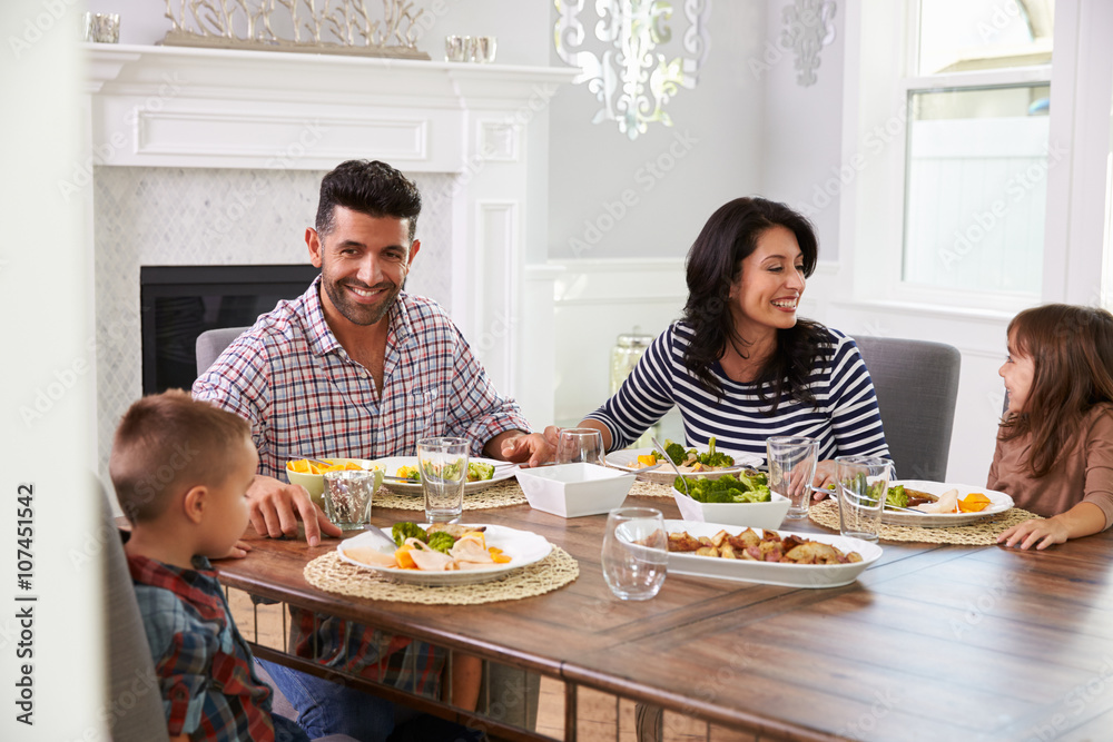 Hispanic Family Enjoying Meal At Table