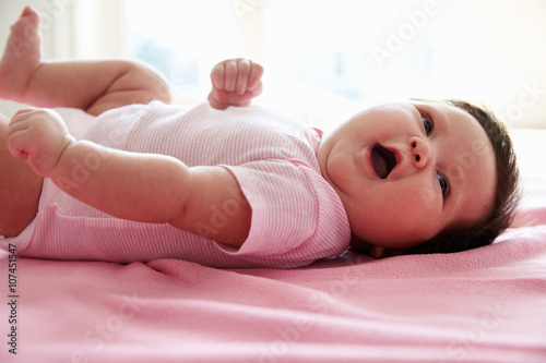 Cute Baby Girl Laying On Pink Blanket