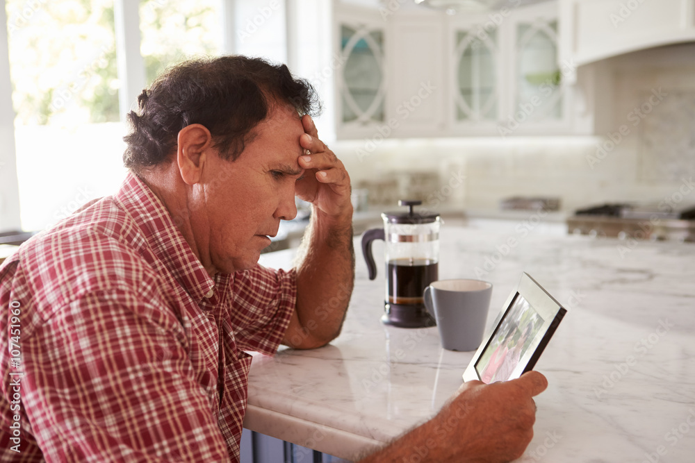Senior Hispanic Man At Home Looking At Old Photograph Senior Hispanic Man At Home Looking At Old Photograph