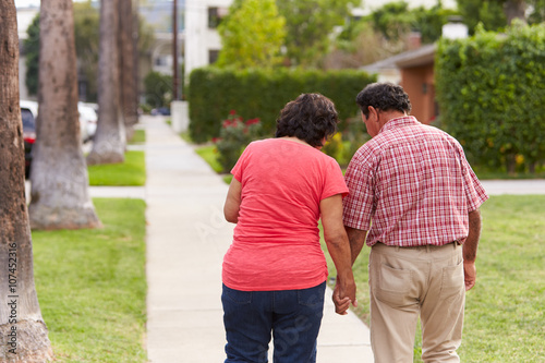 Senior Hispanic Couple Walking Along Sidewalk Together © Monkey Business