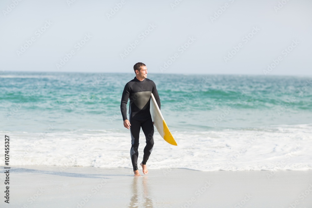 Surfer walking on the beach with a surfboard Surfer walking on the beach with a surfboard