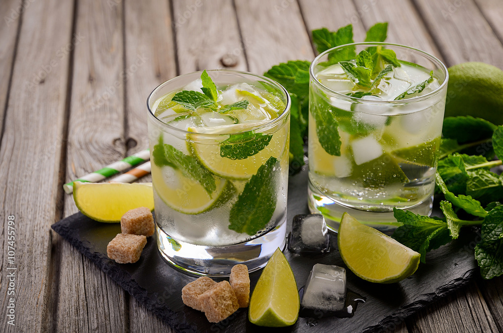 Fresh mojito cocktail with lime and mint on rustic wooden background Fresh mojito cocktail with lime and mint on rustic wooden background