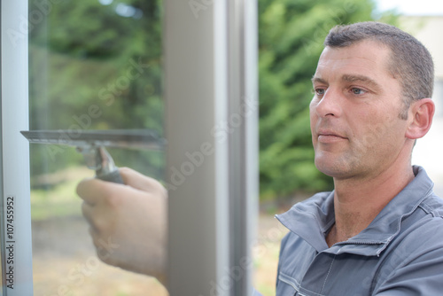 Photos Man wiping window with squeegee