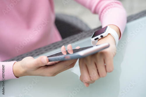 Woman using smart watch to connect with cellphone