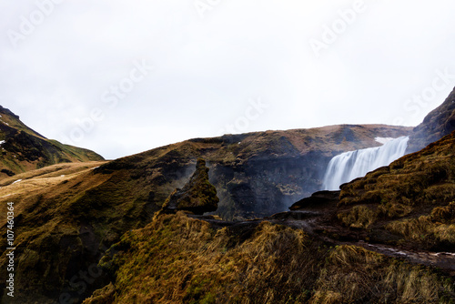 the famous troll rock overlooking Skogafoss waterfall in sout Iceland