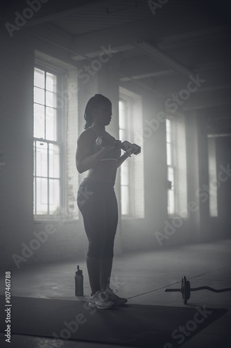 Wallpaper Mural Black woman lifting weights in dark gym Torontodigital.ca