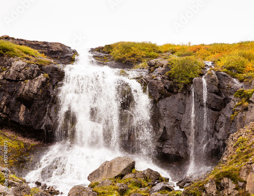 Fototapeta Naklejka Na Ścianę i Meble -  Waterfall in Skutulsfjordur.  A waterfall located in the fjord of Skutulsfjordur a short distance from the town of Isafjordur in North West Iceland.